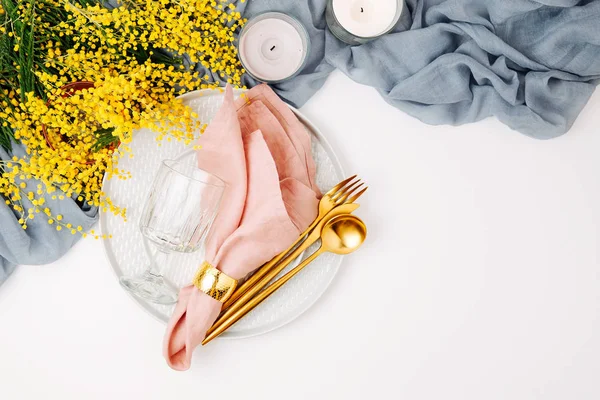 お祝いテーブル設定 皿やカトラリー灰色装飾的な織物と白い背景の上の黄色の花 美しいアレンジメント — ストック写真