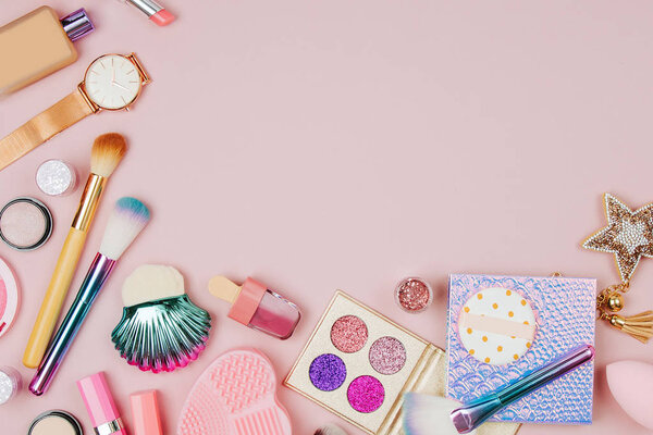 Коллаж женской косметики с помадой, кистью и другими аксессуарами на розовом фоне. Плоский, вид сверху
.
