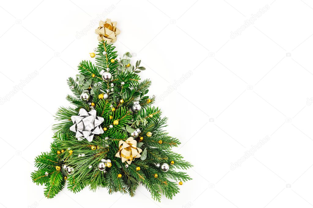 Christmas tree made of fir and pine branches with Christmas decorations on white background. Holiday concept. Flat lay, top view