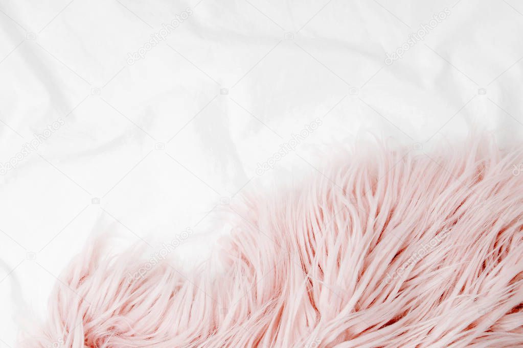 Bedding with a pink fluffy fur plaid. Copy space. Flat lay, top view