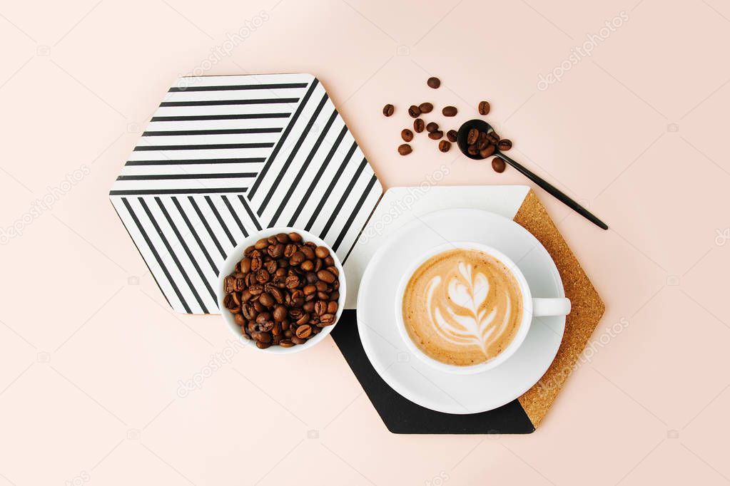 Coffee with milk and coffee beans on pink background