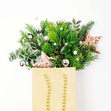 Parlak Noel süsleri ve çam dalları beyaz bir arka plan üzerinde alışveriş torbasında. Noel alışveriş kavramı. Düz yatıyordu, en iyi görünümü