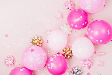 Konfeti, yay ve kağıt süslemeleri ile pembe balonlar. Doğum günü partisi konsepti tema. Düz yatıyordu, en iyi görünümü