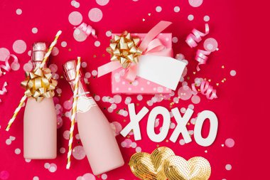 Şampanya şişeleri konfeti ve tinsel kırmızı arka plan ile. Sevgililer günü veya Doğum günü partisi konsepti tema. Düz yatıyordu, en iyi görünümü