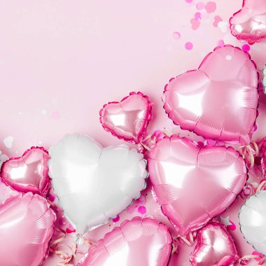 Hava balonları, kalp folyo pastel pembe bir arka plan üzerinde şeklinde. Aşk kavramı. Tatil kutlaması. Sevgililer günü veya düğün/bachelorette parti dekorasyon. Metalik balon