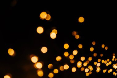 Siyah zemin üzerine altın bokeh ışıltı soyut. Işıklar bulanık bokeh Noel tasarımı için