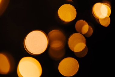 Siyah zemin üzerine altın bokeh ışıltı soyut. Işıklar bulanık bokeh Noel tasarımı için
