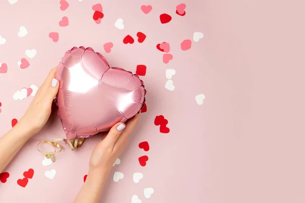 Vrouwelijke Handen Houd Ballon Van Hartvormige Folie Pastel Roze Achtergrond — Stockfoto