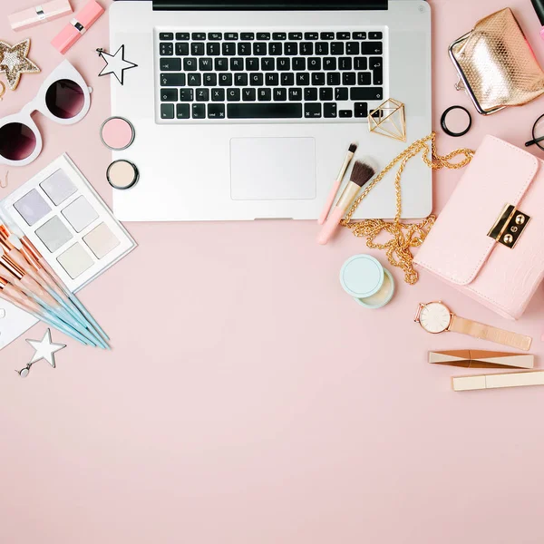 Moda blogger çalışma alanıyla soluk pembe tablo üzerinde laptop ve erkek Aksesuar, kozmetik ürünleri. düz yatıyordu, en iyi görünümü