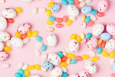 Şeker çikolata yumurta ve pembe bir arka plan üzerinde Jellybean