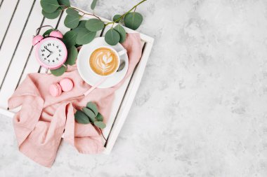 Beyaz ahşap servis tepsi ile çalar saat ve okaliptüs şube Kupası kahve ile üstten görünüm