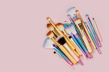 Pastel pembe arka plan çeşitli makyaj fırçaları moda