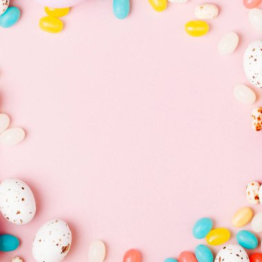 Şık çerçeve şeker çikolata yumurta ve jelibon, pembe arka plan yapılmış