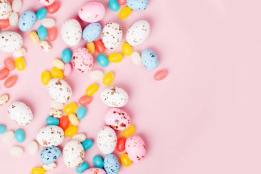 Şeker çikolata yumurta ve pembe bir arka plan üzerinde Jellybean