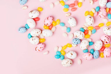 Şeker çikolata yumurta ve pembe bir arka plan üzerinde Jellybean