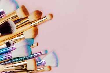 Pastel pembe arka plan çeşitli makyaj fırçaları moda
