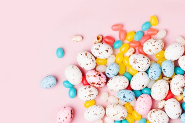 Şeker çikolata yumurta ve parti kağıt çanta pembe bir arka plan üzerinde üzerinden akan Jellybean