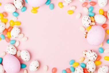 Şık çerçeve şeker çikolata yumurta ve jelibon, pembe arka plan yapılmış