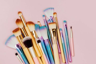 Pastel pembe arka plan çeşitli makyaj fırçaları moda