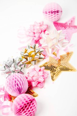 Beyaz arka plan üzerinde pastel pembe konfeti, yay ve kağıt süsleme 