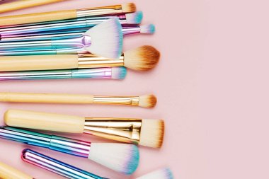 Pastel pembe arka plan çeşitli makyaj fırçaları moda