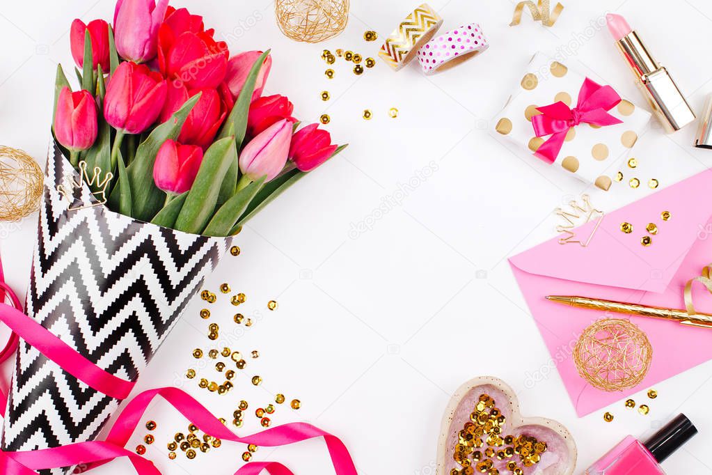 Pink tulips in black and white stylish wrapping paper, gifts, cosmetics and female accessories with confetti on white background