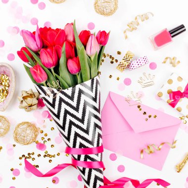 Pembe ve altın tarz Masası çiçekler ile. Siyah ve beyaz şık ambalaj kağıdı, hediyeler, kozmetik ve beyaz zemin üzerine konfeti ile kadın Aksesuarları Pembe Laleler