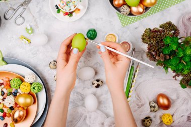 Paskalya dekorasyonu ile çalışma alanı. Kadın Paskalya yumurtaları boyar. Düz yatıyordu, en iyi görünümü