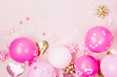 Konfeti, yay ve kağıt süslemeleri ile pembe balonlar. Doğum günü partisi konsepti tema. Düz yatıyordu, en iyi görünümü