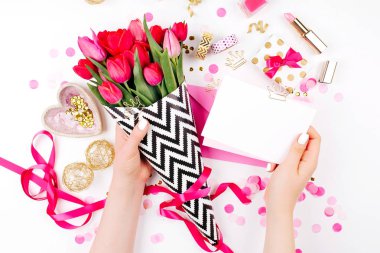 Pembe ve altın tarz masası çiçekler ile. Eller kartları tutun