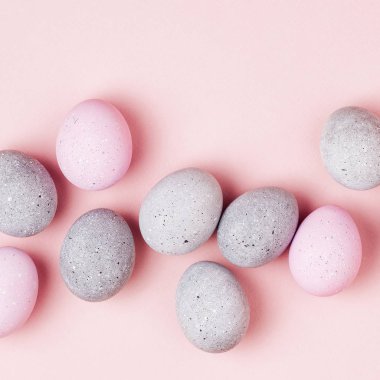 Soluk pembe ve gri Paskalya yumurtaları şık arka plan. Boyalı Paskalya yumurtaları. Düz yatıyordu 