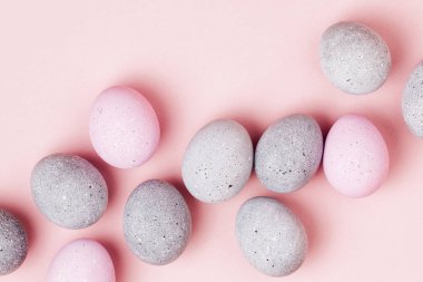 Soluk pembe ve gri Paskalya yumurtaları şık arka plan. Boyalı Paskalya yumurtaları. Düz yatıyordu 