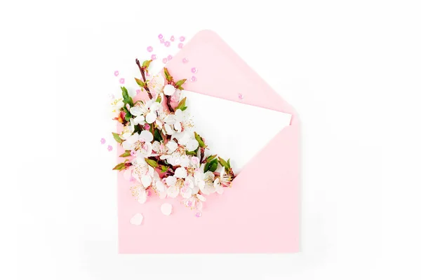粉红色信封与空卡和春天插花安排 顶部视图 — 图库照片