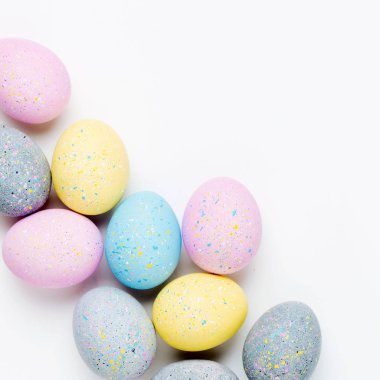 Soluk pembe, mavi, sarı ve gri Paskalya yumurtaları ile arka plan. Besteleri pastel renklerde. Paskalya kavramı