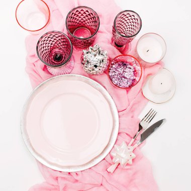 Sofra pastel pembe ve beyaz renklerle, vintage kadehler, yeşil yaprakları beyaz arka plan üzerinde izole bileşimi