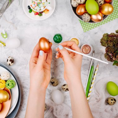 Paskalya dekorasyonu ile çalışma alanı. Kadın Paskalya yumurtaları boyar. Düz yatıyordu, en iyi görünümü