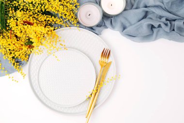 Festival Tablo ayarı. Tabak ve çatal bıçak takımı gri dekoratif Tekstil ve beyaz zemin üzerine sarı çiçekleri ile. Güzel aranjman.