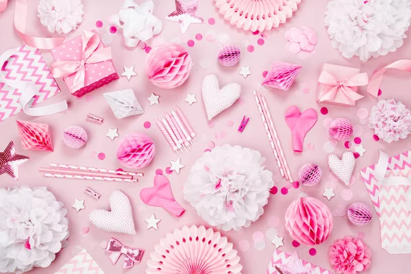 Pink and white Paper Decorations, pom-pom, candy, hearts, gifts, confetti for Baby party. Birthday concept.  Flat lay, top view