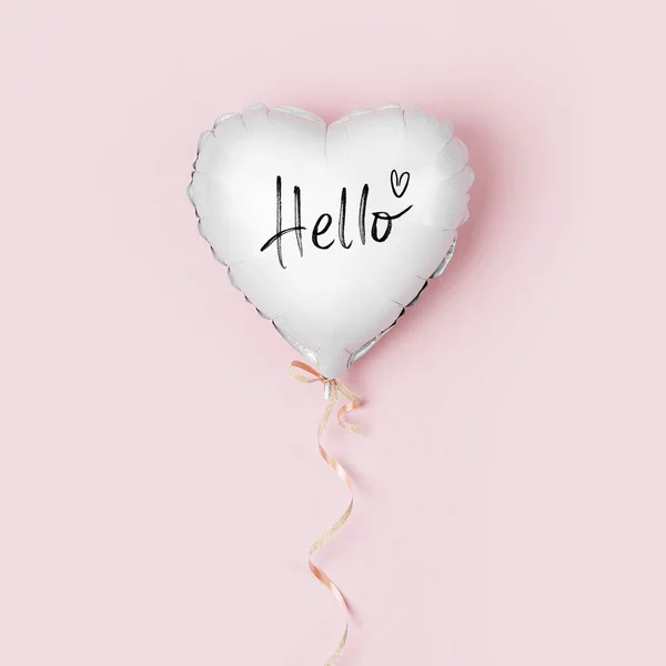 Single Balloon of heart shaped foil on pastel pink background. Love concept. Holiday celebration. Valentine\'s Day or wedding/bachelorette party decoration. Metallic balloon