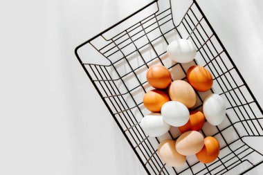 Siyah metal sepet sunlights ile doğal renkli yumurtalar. Şık yaşam tarzı kompozisyonlar. Paskalya kavramı. 