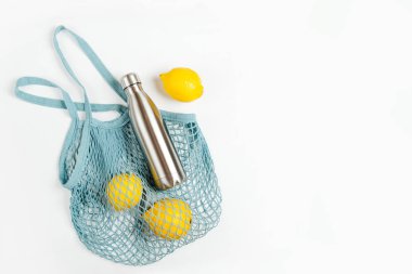 Yeniden kullanılabilir metal su şişesi ve meyve ile pamuk net çanta. Sürdürülebilir bir yaşam tarzı. Eko Dostu kavramı.