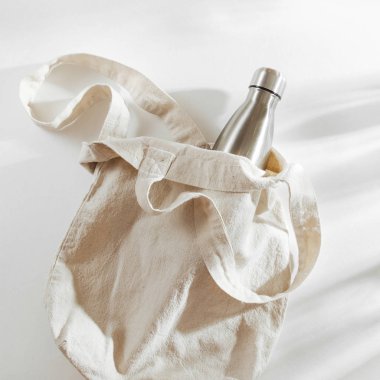 Yeniden kullanılabilir metal su şişesi ile doğal renk Eko çanta. Sıfır atık kavramı. Plastik ücretsiz. Düz yatıyordu, en iyi görünümü