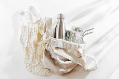 Yeniden kullanılabilir metal su şişe, cam kavanoz ve saman ile doğal renk Eko çanta. Sıfır atık. Sürdürülebilir yaşam tarzı kavramı. 