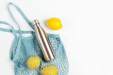 Yeniden kullanılabilir metal su şişesi ve meyve ile pamuk net çanta. Sürdürülebilir bir yaşam tarzı. Eko Dostu kavramı.