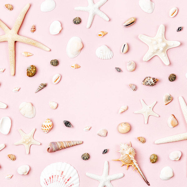 Seashells and starfish on a pale pink background.  Summer time concept. Nautical pattern. 