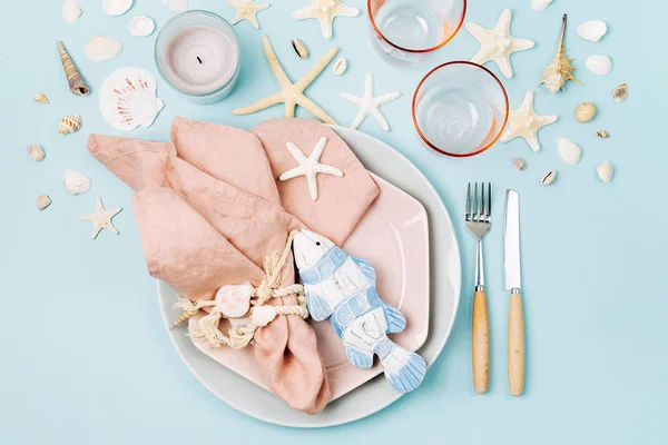 お祝いテーブルを提供するため食器や海の装飾です プレート ワイングラスと青色の背景色の食器 夏のコンセプトです フラット横たわっていた トップ ビュー — ストック写真