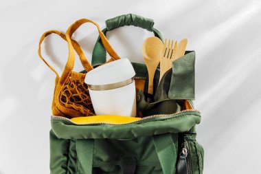 Yeşil sırt çantası ile mesh Pazar çantası, bambu çatal ve yeniden kullanılabilir kahve kupa. Sürdürülebilir bir yaşam tarzı. Sıfır atık, plastik ücretsiz kavramı.