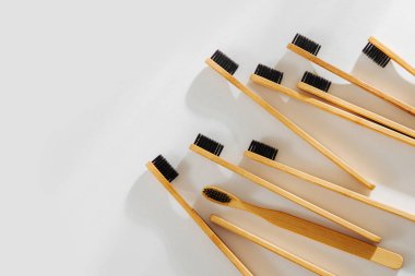 Ahşap Eko bambu diş fırçası ile beyaz arka planda siyah kıl. Sürdürülebilir bir yaşam tarzı. Sıfır atık kavramı.