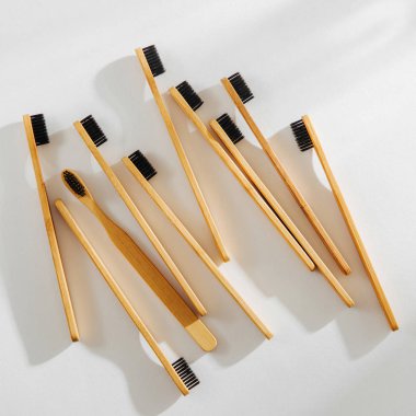 Ahşap Eko bambu diş fırçası ile beyaz arka planda siyah kıl. Sürdürülebilir bir yaşam tarzı. Sıfır atık kavramı.