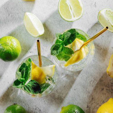 İki bardak limonata ya da mojito kokteyli. Taze narenciye ve buzlu yaz içecekleri..
